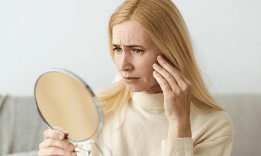 Woman Looking at Skin in Mirror